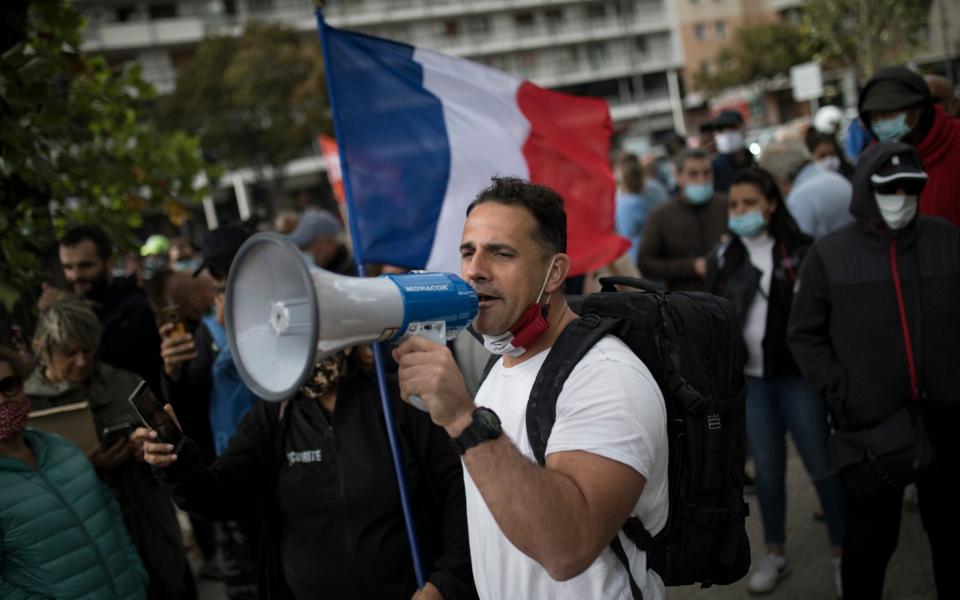 Restaurant owners demonstrate outside the gates of La Timone public hospital as French Health Minister Olivier Veran visits in Marseille, southern France, - Daniel Cole/AP