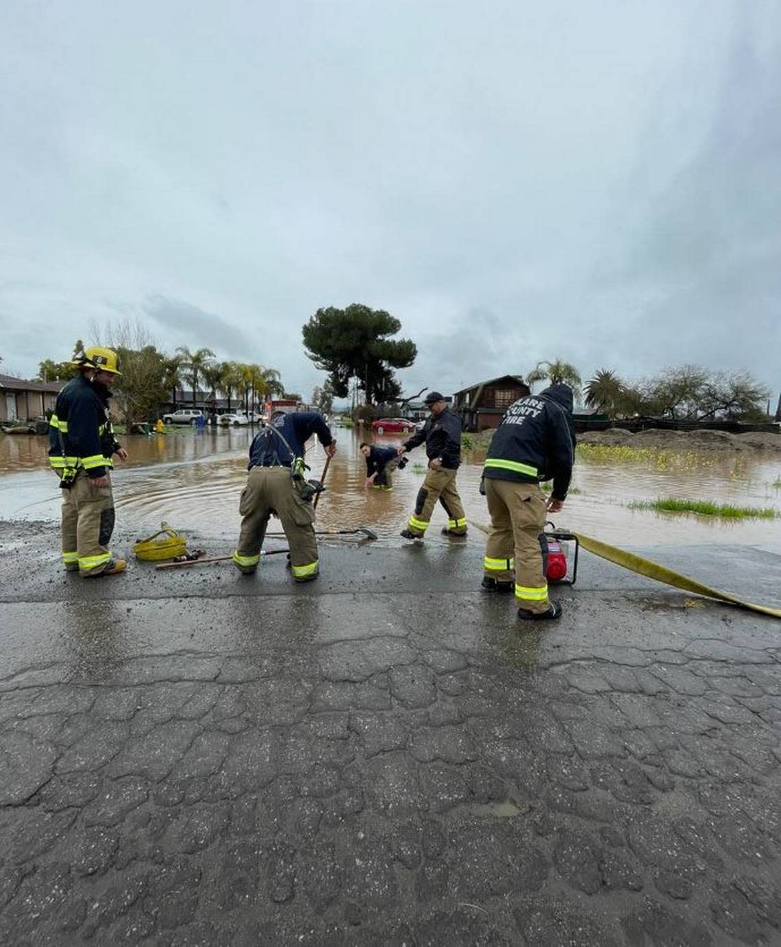 Tulare County firefighters work to control flooding in the communities of Seville and Yettem Saturday.