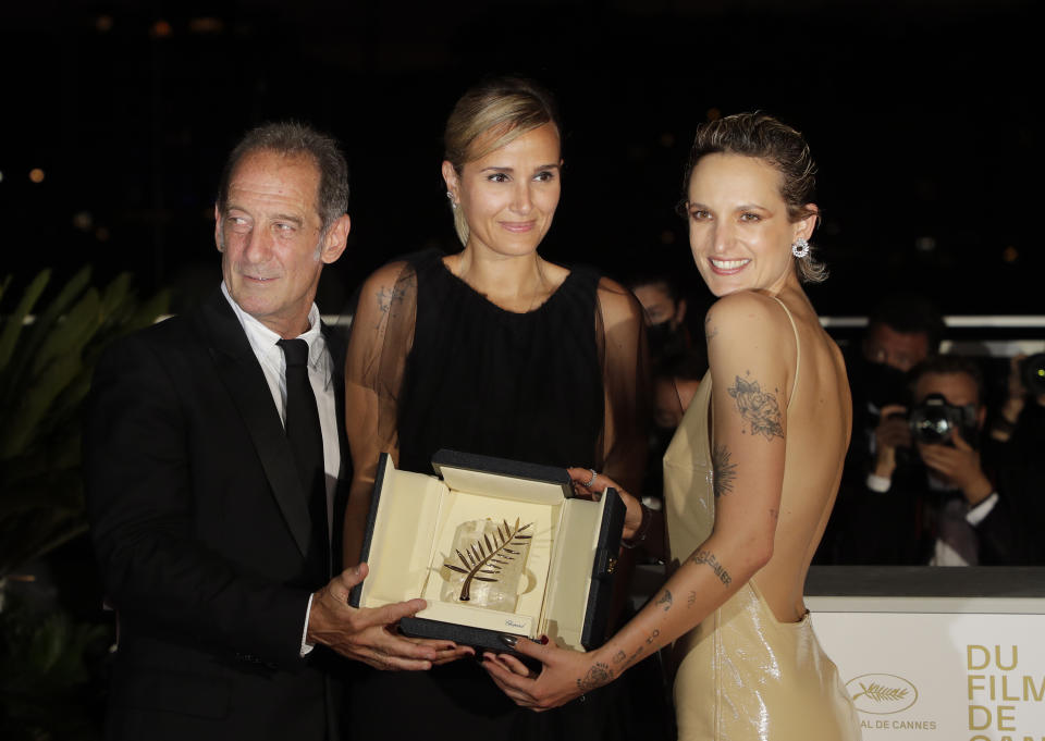 Director Julia Ducournau, center, winner of the Palme d'Or for the film 'Titane' poses with Vincent Lindon, left, and Agathe Rousselle during a photo call following the awards ceremony at the 74th international film festival, Cannes, southern France, Saturday, July 17, 2021. (Photo by Vianney Le Caer/Invision/AP)