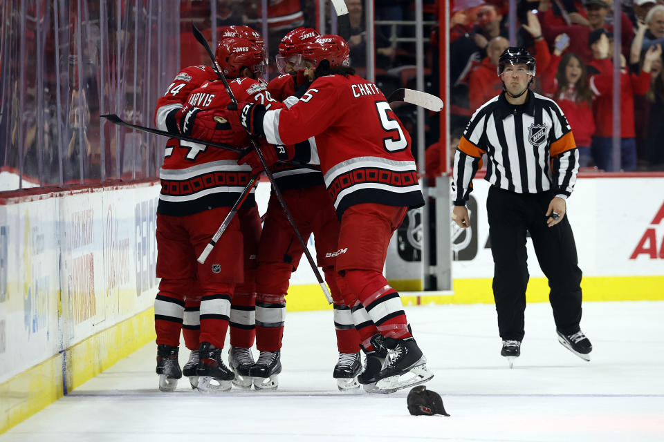 Carolina Hurricanes surround Seth Jarvis (24) to celebrate his hat trick goal during the third period of an NHL hockey game against the Montreal Canadiens in Raleigh, N.C., Thursday, Feb. 16, 2023. (AP Photo/Karl B DeBlaker)