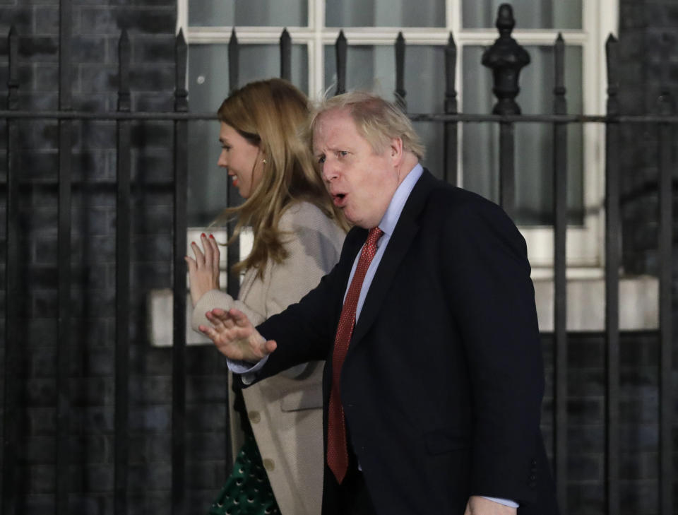 Britain's Prime Minister Boris Johnson and his partner Carrie Symonds arrive back in Downing Street in London, Friday, Dec. 13, 2019. Prime Minister Boris Johnson's Conservative Party has won a solid majority of seats in Britain's Parliament — a decisive outcome to a Brexit-dominated election that should allow Johnson to fulfill his plan to take the U.K. out of the European Union next month. (AP Photo/Matt Dunham)