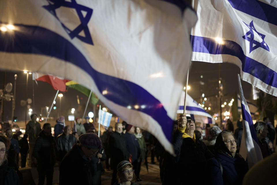 Holding up Israeli flags people take part in a protest against humanitarian aid entering Gaza and against the hostages exchange deal with Hamas, in Jerusalem, Israel, Thursday, Jan. 25, 2024. (AP Photo/Leo Correa)