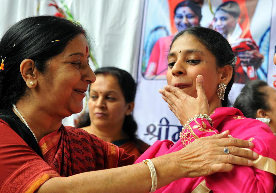 Geeta expresses herself through gestures as Sushma Swaraj looks on at Indore Deaf Bilingual Academy (IDBA) on November 23, 2015. (Photo by Shankar Mourya/Hindustan Times via Getty Images)