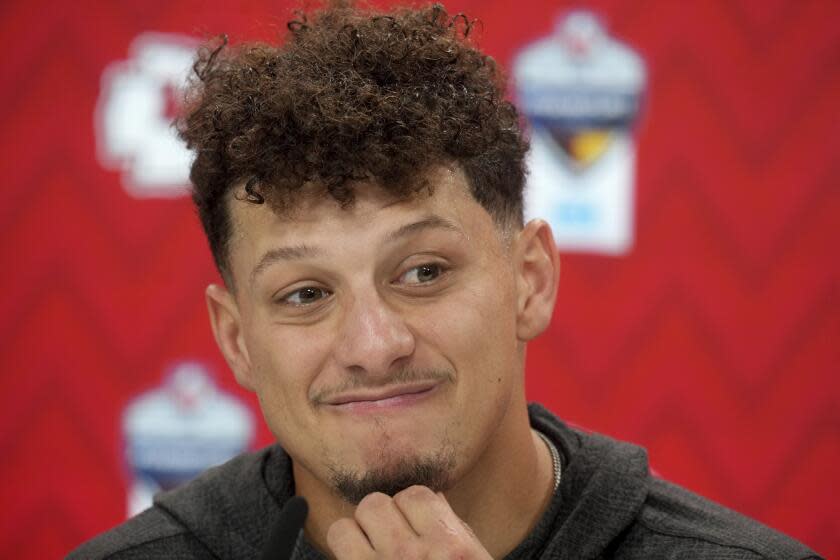 Kansas City Chiefs quarterback Patrick Mahomes rubs his chin as he speaks during a news conference