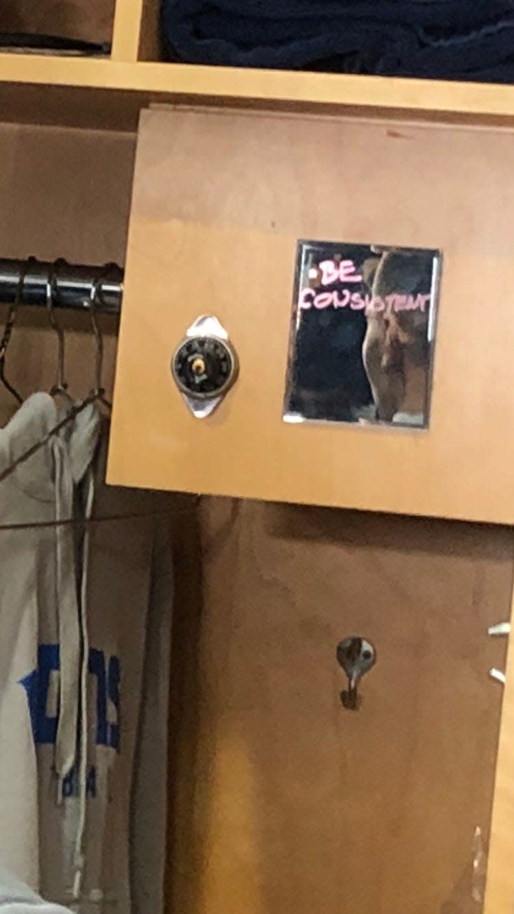 A look at Lions wide receiver Amon-Ra St. Brown's locker, which has a mirror with "Be Consistent" written on it.