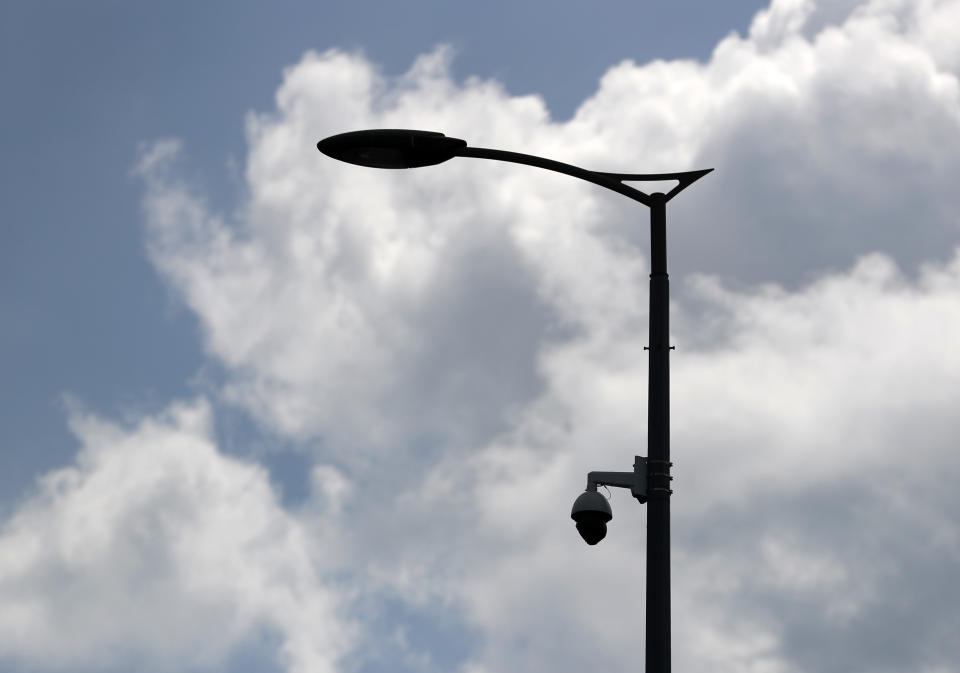 In this photo taken July 17, 2019, a high-tech video camera hangs from a lamppost in Belgrade, Serbia. A video surveillance system with facial recognition by Chinese tech giant Huawei is being rolled out across hundreds of cities worldwide, particularly in poor countries with weak track records on human rights where Beijing has increased its influence through big business deals. (AP Photo/Darko Vojinovic)