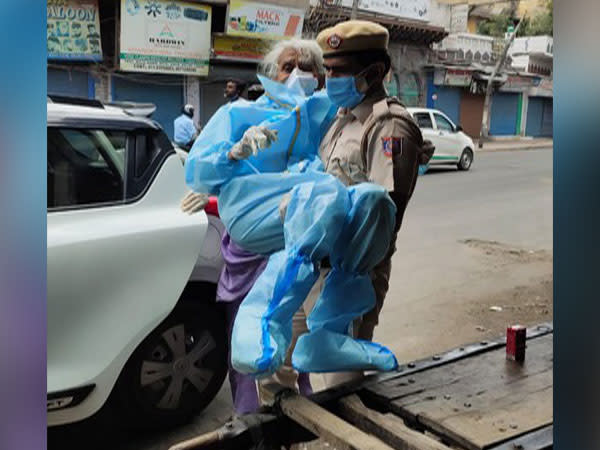 Delhi Police constable Kuldeep Singh carrying Shaila D'Souza to vaccination centre.