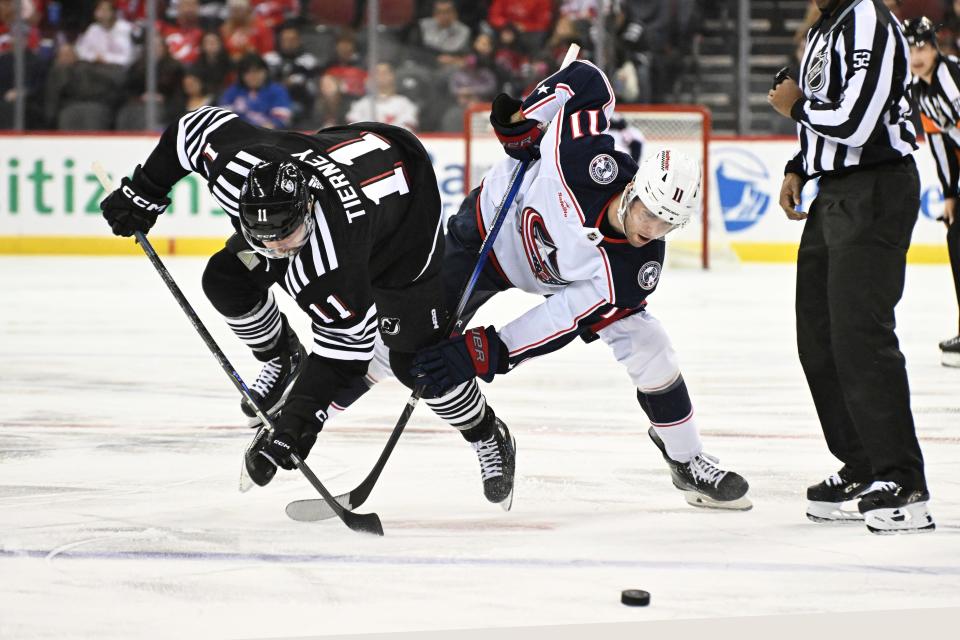 Columbus Blue Jackets center Adam Fantilli, right, battles for control of the puck with New Jersey Devils center Chris Tierney during the first period of an NHL hockey game Friday, Nov. 24, 2023, in Newark, N.J. (AP Photo/Bill Kostroun)