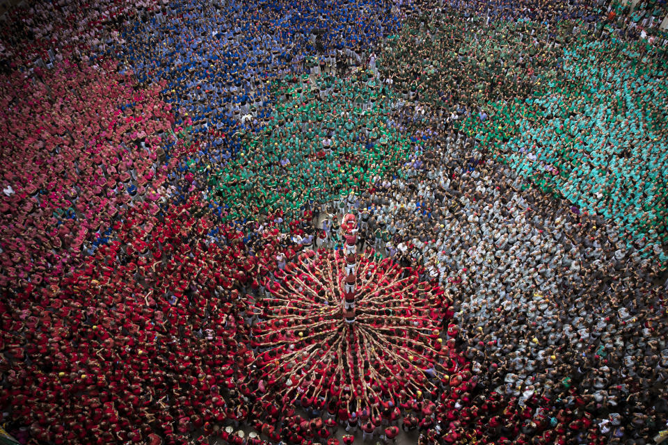 FILE - In this Sunday, Oct. 7, 2018 file photo members of the "Colla Joves Xiquets de Valls" complete their human tower during the 27th Human Tower Competition in Tarragona, Spain. The tradition of building human towers or "castells" dates back to the 18th century and takes place during festivals in Catalonia, where "colles" or teams compete to build the tallest and most complicated towers. "Castells" were declared by UNESCO one of the Masterpieces of the Oral and Intangible Heritage of Humanity. (AP Photo/Emilio Morenatti, File)