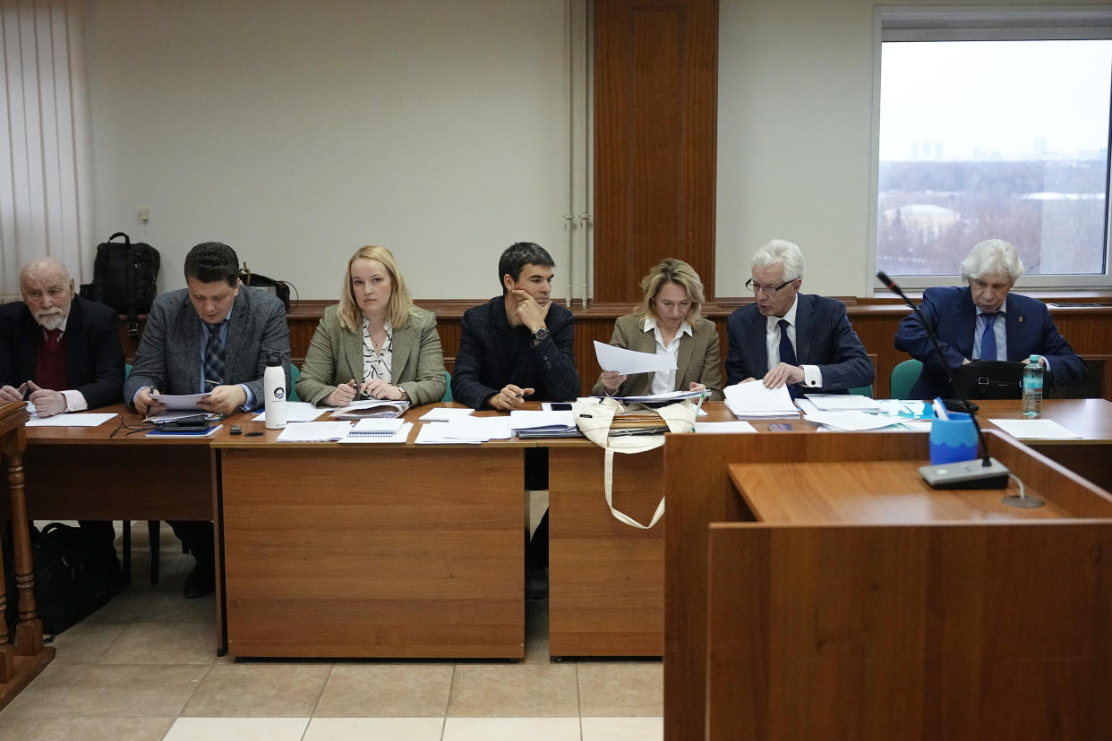 Members of the Moscow Helsinki Group and their lawyers talk in the courtroom before a hearing on the lawsuit to liquidate the Moscow Helsinki Group in Moscow, Russia, Wednesday, Jan. 25, 2023. The Moscow Helsinki Group is one of the country's oldest human rights organizations. (AP Photo/Alexander Zemlianichenko)