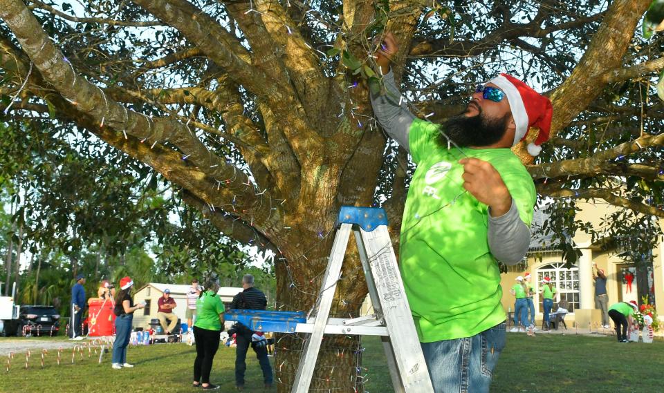 Lester De La O , a lineman with FPL, was one of the volunteers to honor a veteran. Florida Power & Light Company volunteers teamed up with the Military Order of the Purple Heart and the Brevard Veterans Memorial Center to surprise a U.S. Marine Corps veteran and his family with an energy-efficient holiday light display that they can keep.