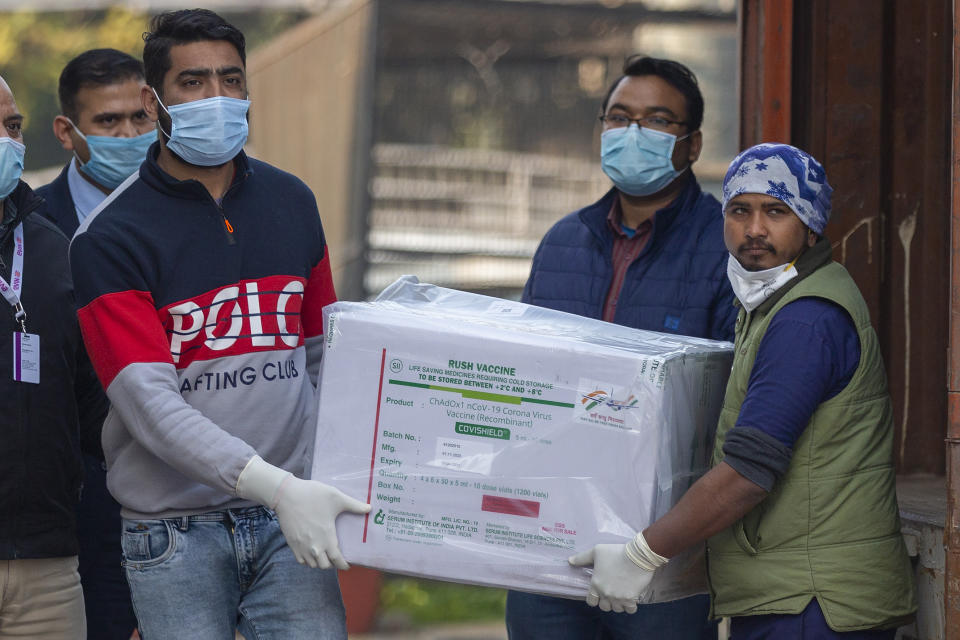 Health workers shift a box containing COVID-19 vaccine from a vehicle to a cold storage at Rajiv Gandhi Super Speciality hospital in New Delhi, India, Tuesday, Jan. 12, 2021. On Jan. 16 India will start the massive undertaking of inoculating an estimated 30 million doctors, nurses and other front line workers, before attention turns to around 270 million people who are either aged over 50 or have co-morbidities.(AP Photo/Altaf Qadri)