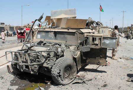 Afghan National Army (ANA) soldiers inspect damaged army vehicles after a suicide attack in Lashkar Gah, Helmand province, Afghanistan August 23, 2017. REUTERS/Stringer NO RESALES. NO ARCHIVES