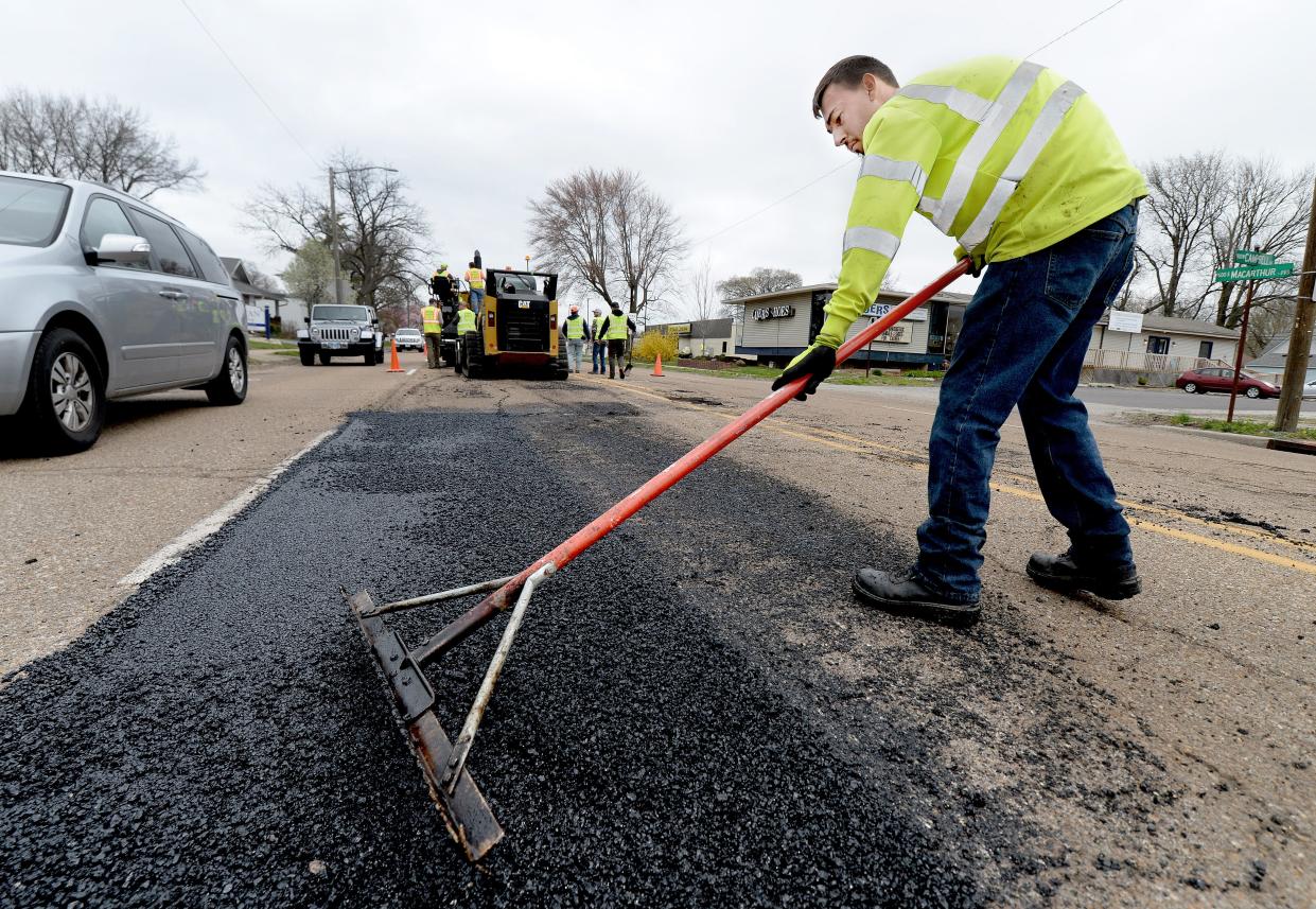 United Contractors Midwest employee Max Windsor works on repairing damage to South MacArthur Boulevard on April 1.