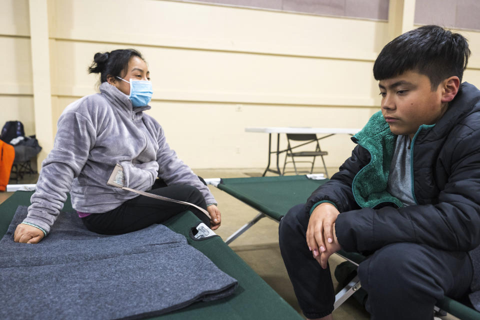 Oliver Gonzalez (right) sits with his mother Eusebia Gonzalez at an evacuation center at Santa Cruz County fairgrounds in Watsonville, Calif., Saturday, March 11, 2023. They were evacuated from their home in Pajaro at 5:00am on Saturday. (AP Photo/Nic Coury)