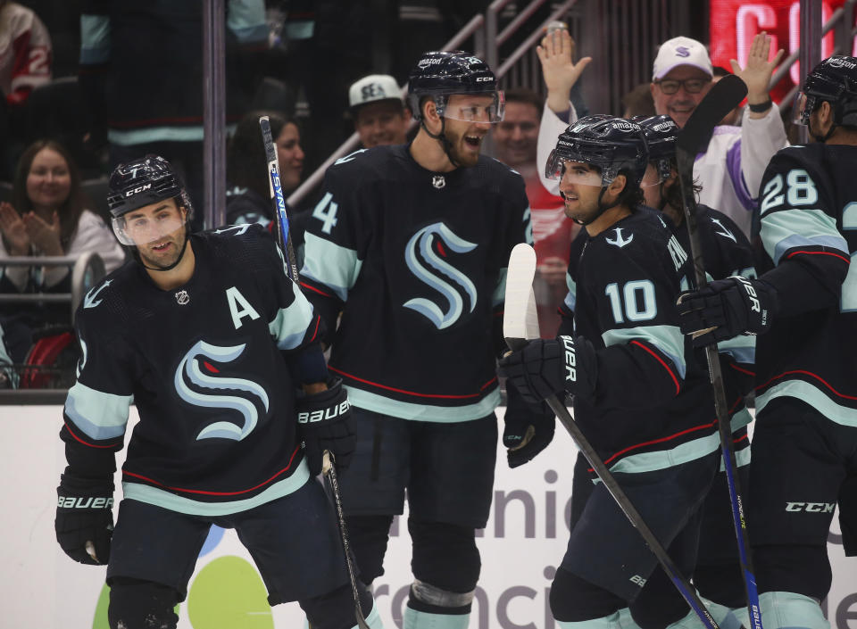 Seattle Kraken right wing Jordan Eberle (7) celebrates his second goal of the night against the Detroit Red Wings with Jamie Oleksiak (24) and Matty Beniers (10), during the second period of an NHL hockey game Saturday, Feb. 18, 2023, in Seattle. (AP Photo/ Lindsey Wasson)