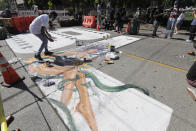 An artist paints one of the large letters that read "Black Lives Matter" on a street near Cal Anderson Park, Thursday, June 11, 2020, inside what is being called the "Capitol Hill Autonomous Zone" in Seattle. Following days of violent confrontations with protesters, police in Seattle have largely withdrawn from the neighborhood. (AP Photo/Ted S. Warren)