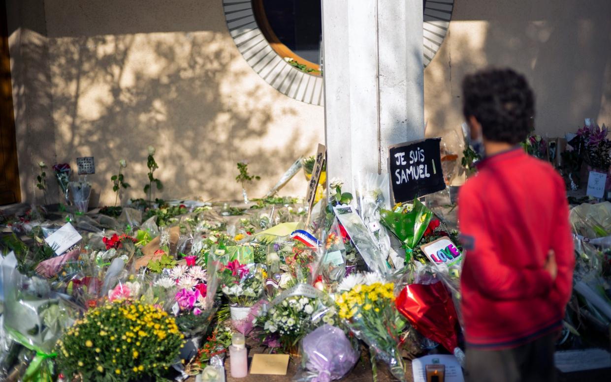 People lay flowers in front of the middle-school where murdered school teacher Samuel Paty taught  - Aurelien Meunier/Getty Images