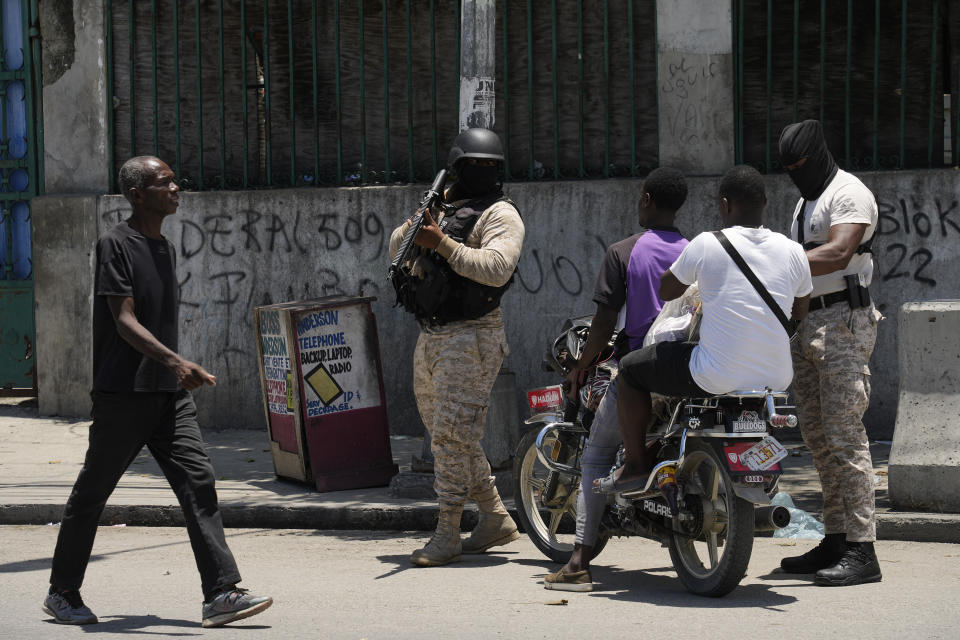 Police check motorists near the National Palace amid the sound of gunshots in the distance in Port-au-Prince, Haiti, Tuesday, April 30, 2024. (AP Photo/Ramon Espinosa)