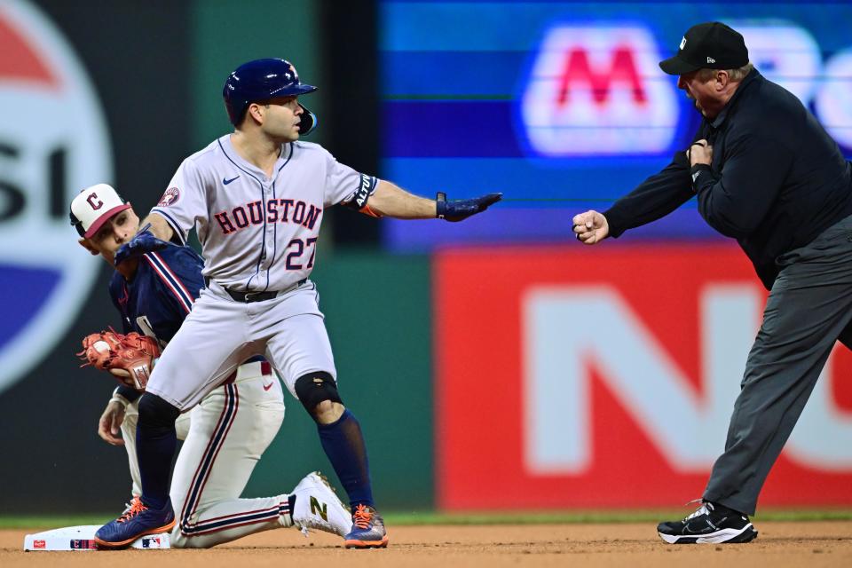 Sep 27, 2024; Cleveland, Ohio, USA; Houston Astros second baseman Jose Altuve (27) motions safe as umpire Bruce Drekman calls him out during the first inning at Progressive Field. Altuve was safe with a double on the play after review. Mandatory Credit: Ken Blaze-Imagn Images