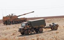 Turkish army vehicles and military personnel are stationed near the Turkish-Syrian border in Sanliurfa province