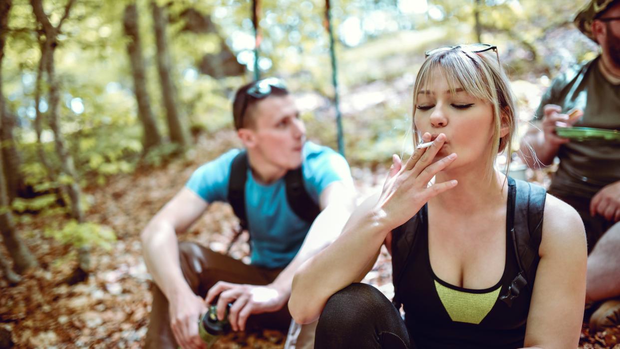  Female Hiker Smoking During Break In Forest 