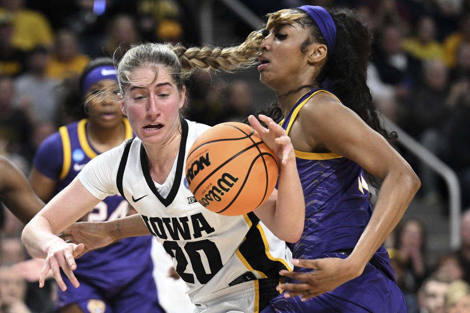 Iowa guard Kate Martin (20) drives against LSU forward Angel Reese (10) during the first half of an Elite Eight round college basketball game during the NCAA Tournament, Monday, April 1, 2024, in Albany, N.Y. (AP Photo/Hans Pennink)