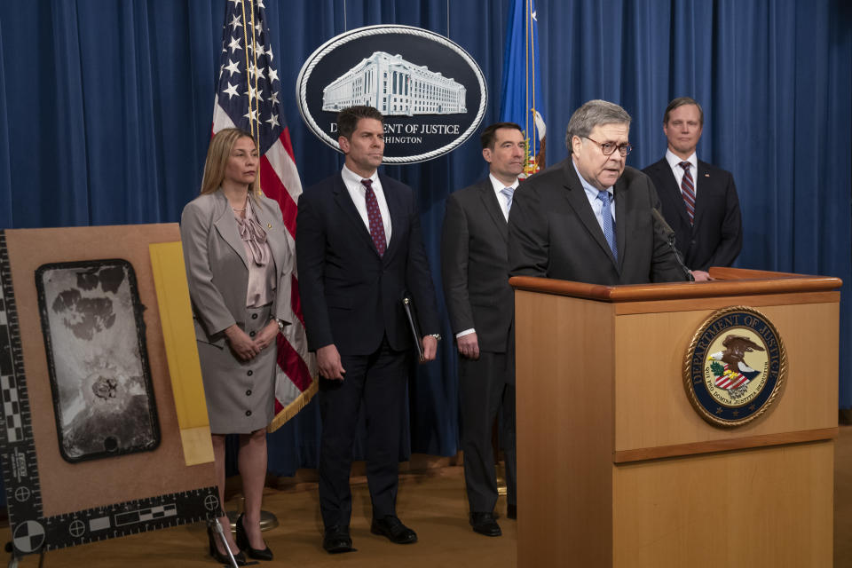 FILE - In this Jan. 13, 2020, file photo Attorney General William Barr and FBI Deputy Director David Bowdich, second from left, address reporters at the Justice Department in Washington to announce results of an investigation of the shootings at the Pensacola Naval Air Station in Florida. An an image of an iPhone is displayed at left. The Justice Department has placed a high national-security priority on its probe of the incident, insisting that investigators must get access to data from two locked and encrypted iPhones that belonged to the alleged gunman, a Saudi aviation student. (AP Photo/J. Scott Applewhite)