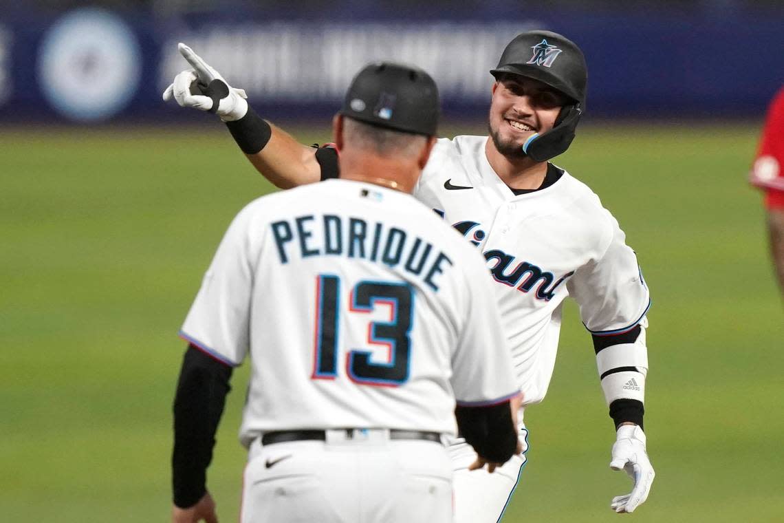 Miami Marlins’ Jordan Groshans, right, is met by third base coach Al Pedrique while rounding third base after hitting a solo home run during the third inning of the team’s baseball game against the Philadelphia Phillies, Thursday, Sept. 15, 2022, in Miami. (AP Photo/Lynne Sladky)