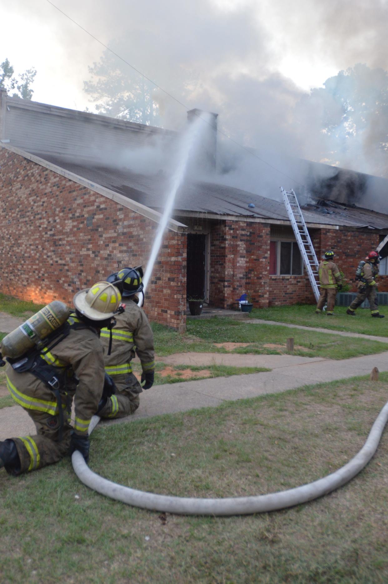 Firefighters work to douse the flames on Pine Valley Apartments building F around 8:30 p.m. Thursday, June 20.