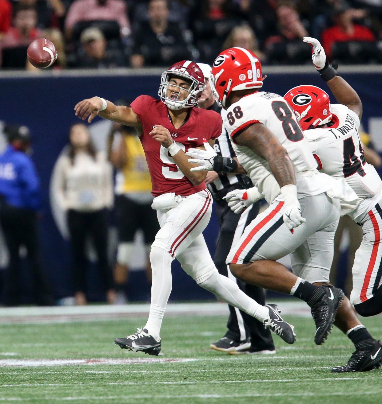 Georgia defenders defensive lineman Travon Walker (44) and defensive lineman Jalen Carter (88) force Alabama quarterback Bryce Young (9) to throw the ball away during the SEC championship game at Mercedes-Benz Stadium. Alabama defeated Georgia 41-24.