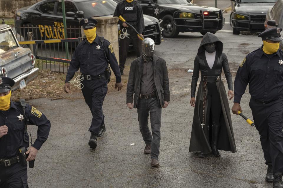 Eccentric masked man Looking Glass (Tim Blake Nelson, center) is a part of a Tulsa police force who hide their identities in "Watchmen."