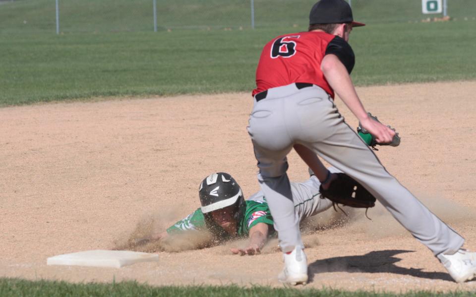 Mendon's Carter Huston dives head first into third base before the throw against White Pigeon in prep baseball action on Thursday.