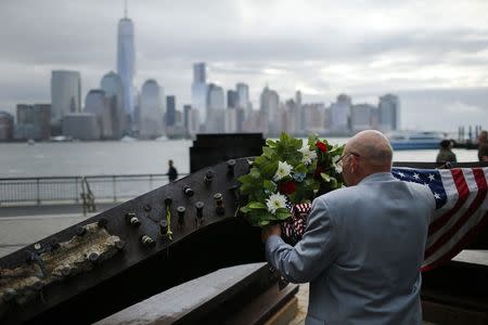 A man places a wreath at the 9/11 memorial during the 13th anniversary of the 9/11 attacks on the World Trade Center, in Exchange Place, New Jersey, September 11, 2014. REUTERS/Eduardo Munoz