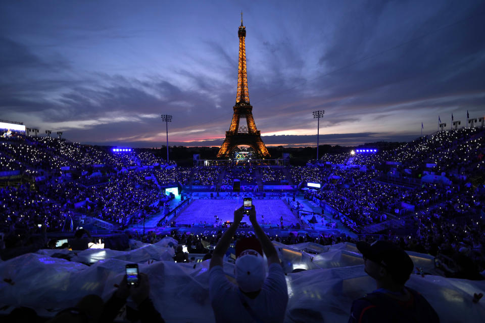 A light show dazzles spectators at Eiffel Tower Stadium ahead of a beach volleyball match between the United States and Canada at the 2024 Summer Olympics in Paris, France, Saturday, July 27, 2024. (AP Photo/Robert F. Bukaty)