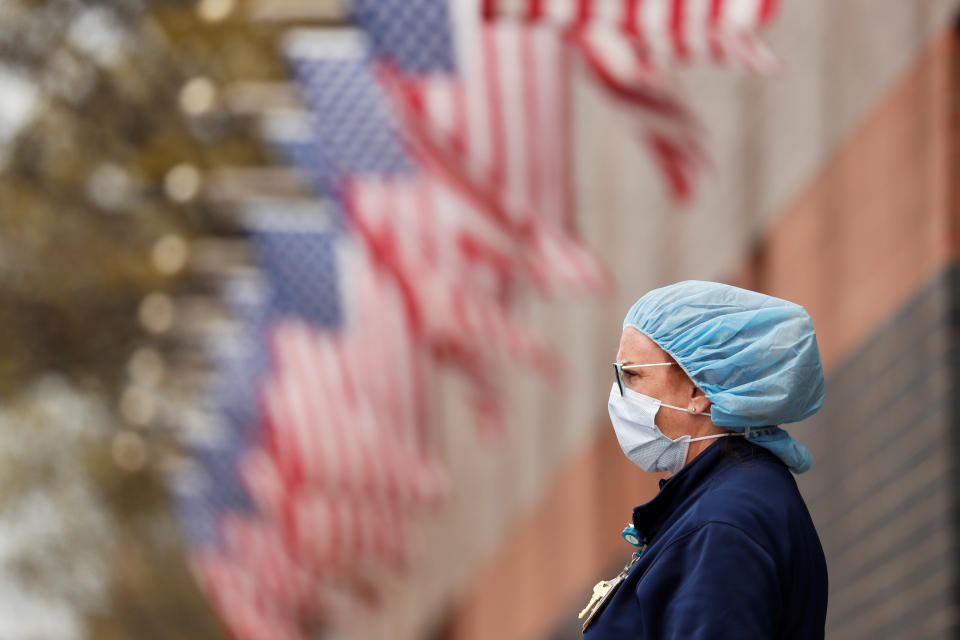 A nurse wearing personal protective equipment watches an ambulance driving away outside of Elmhurst Hospital during the ongoing outbreak of the coronavirus disease (COVID-19) in the Queens borough of New York, U.S., April 20, 2020. REUTERS/Lucas Jackson     TPX IMAGES OF THE DAY