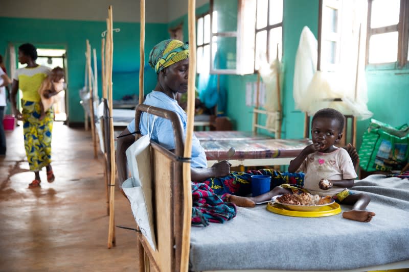 Eme Mbisa, who has become malnourished as a result of a measles infection, eats lunch with her mother, Marianne Mbisa in the measles isolation ward in Boso-Manzi hospital in Mongala province