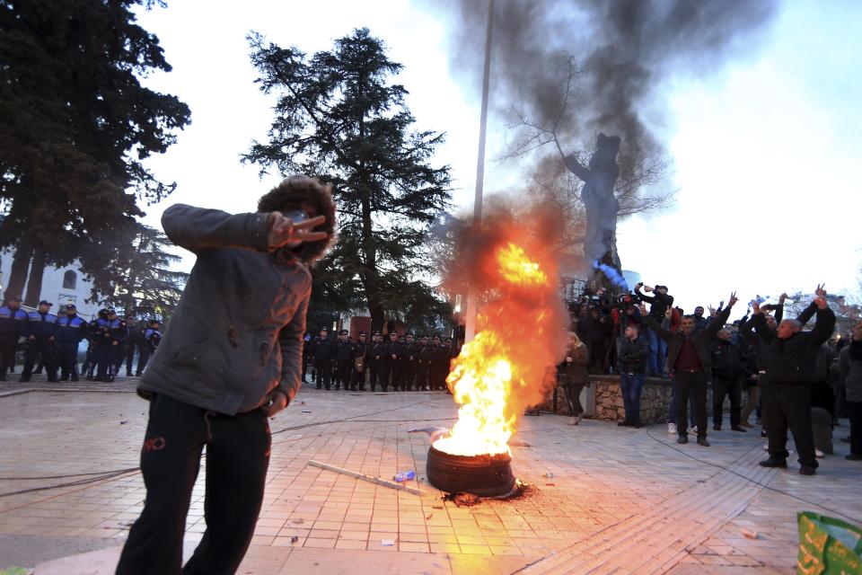 Protesters flash the V-victory sign during an antigovernment rally in Tirana, Tuesday, Feb. 26, 2019. Albanian opposition supporters have surrounded the parliament building and are demanding that the government resign, claiming it's corrupt and has links to organized crime. (AP Photo/Hektor Pustina)