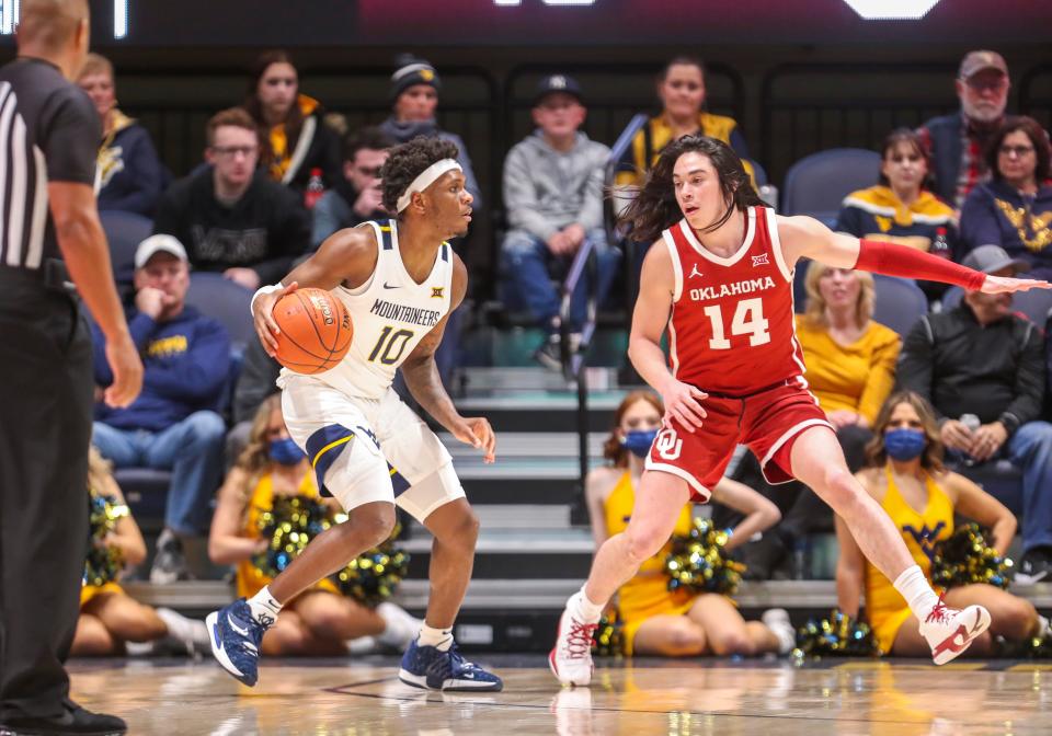 West Virginia Malik Curry (10) looks for an open teammate while being defended by Oklahoma's Bijan Cortes during Wednesday night's game at WVU Coliseum.