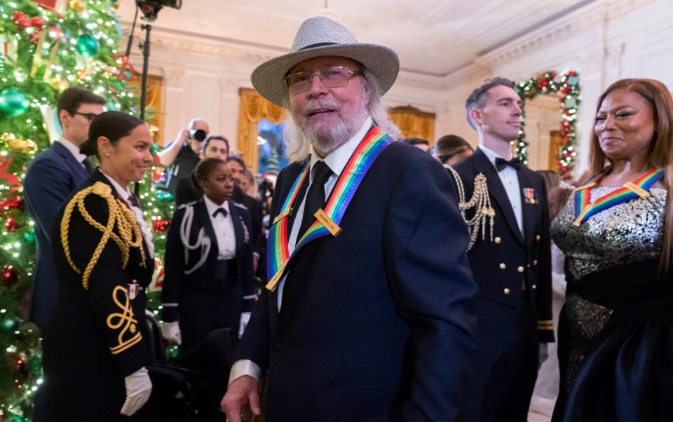 Barry Gibb, an honoree and member of the Bee Gees, joins honoree Queen Latifah, right, at the White House to celebrate