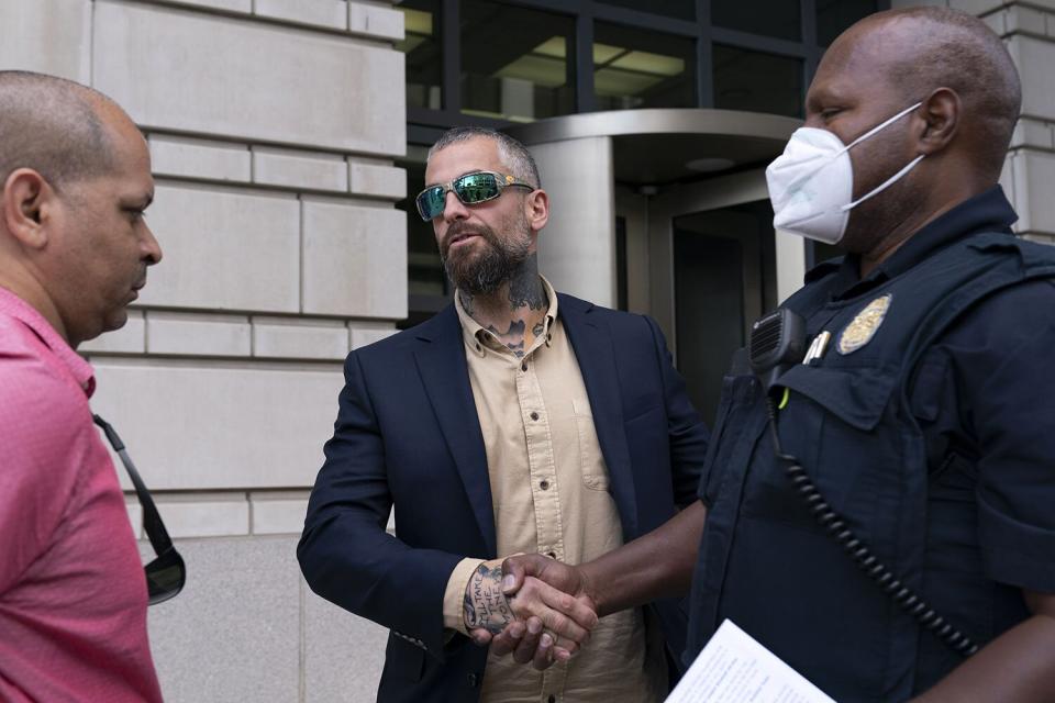 Former D.C. Metropolitan Police Officer Michael Fanone, center, shakes hands with a Capitol Police officer as Capitol Police Sgt. Aquilino Gonell, left, stands by outside the federal courthouse, after Kyle Young, who assaulted Fanone during the Jan. 6 riots, was sentenced to more than seven years in prison after a trial in Washington Capitol Breach-Iowa Arrest, Washington, United States - 27 Sep 2022