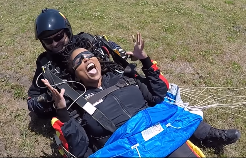 Latonya Leeks, principal at Fort Bragg's Bowely Elementary School, celebrates after she and retired Master Sgt. Sunnydale Hyde, with All Veteran Group, made a tandem jump with a smooth landing onto Polo Field on Friday, May 12, 2023.