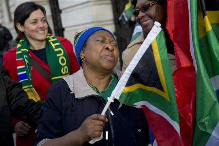 A woman reacts following the death of former South African President Nelson Mandela, at the South African High Commission in London December 6, 2013. REUTERS/Neil Hall