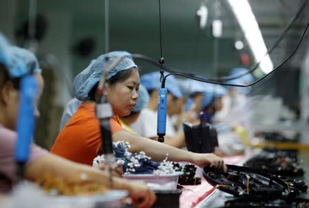 An employee works on the production line of a robot vacuum cleaner at a factory of Matsutek in Shenzhen