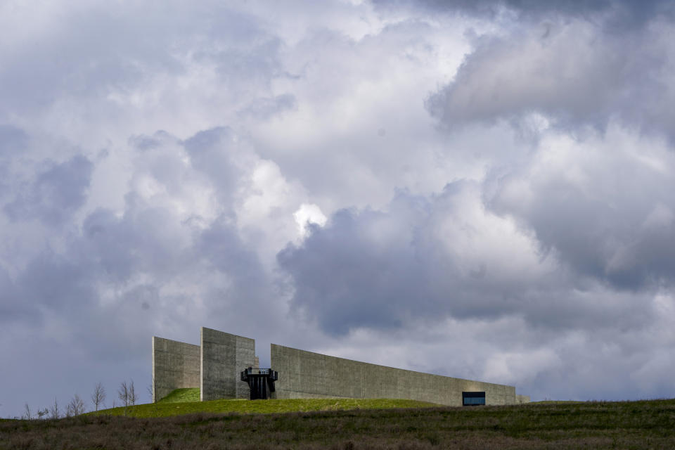 Visitors look from the observation platform at the Flight 93 National Memorial under a cloudy sky on Saturday, May 8, 2021, in Shanksville, Pa. The National Park Service memorial to the people who died on United Airlines Flight 93 is hard to find on a map — as the Sept, 11, 2001, terrorist attack itself slips deeper into the nation's collective memory. Families of Flight 93's 40 passengers and crew members are trying something new to change that: an annual award for heroism. Nominations open Monday through the nonprofit group, Friends of Flight 93 National Memorial. (AP Photo/Keith Srakocic)