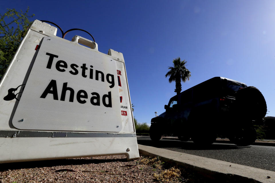 FILE - In this May 23, 2020, file photo, a vehicle arrives at COVID-19 testing site at Steele Indian School Park, in Phoenix. Coronavirus cases are rising in nearly half the U.S. states, as states are rolling back lockdowns. (AP Photo/Matt York, File)