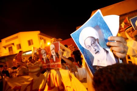 Protesters holding photos of Bahrain's leading Shi'ite cleric Isa Qassim shout religious slogans during a sit-in outside his home in the village of Diraz west of Manama, Bahrain July 27, 2016. REUTERS/Hamad I Mohammed