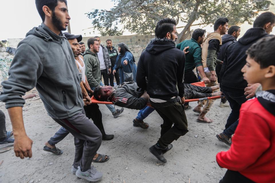 Palestinian citizens carry out search and rescue operations in the destruction caused by Israeli air strikes on December 7, 2023, in Khan Yunis, Gaza.