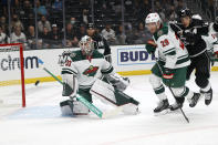 Minnesota Wild goalie Cam Talbot (33) looks at the puck as defenseman Dmitry Kulikov (29) defends against Los Angeles Kings forward Dustin Brown (23) during the first period of an NHL hockey game Saturday, Oct. 16, 2021, in Los Angeles. (AP Photo/Ringo H.W. Chiu)