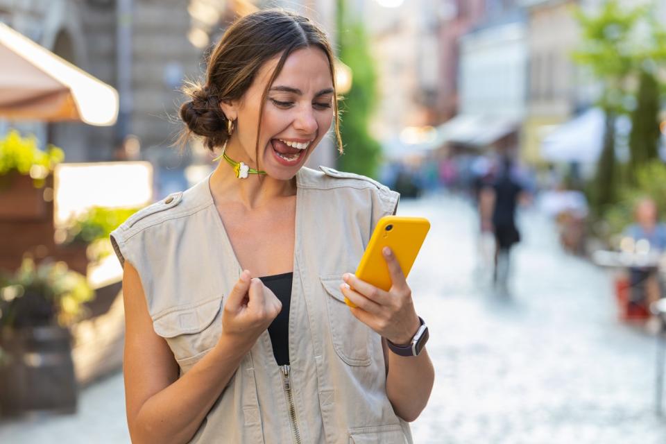 Young person outdoors with smartphone.